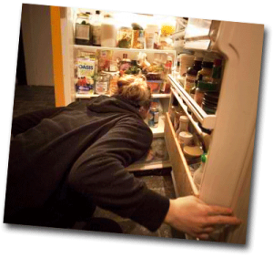 Femme fouillant dans le frigo pendant la nuit